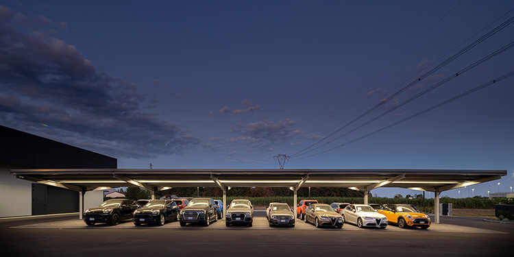 Beleuchteter Carport mit Fahrzeugen bei Nacht